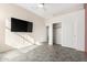 Bright bedroom featuring a mounted TV and tile floors at 17937 W Weatherby Dr, Surprise, AZ 85374