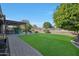 Landscaped backyard with a pergola, fire pit, and grassy area at 19204 W Oregon Ave, Litchfield Park, AZ 85340