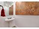 Clean and modern bathroom with pedestal sink, large mirror, and art at 19204 W Oregon Ave, Litchfield Park, AZ 85340