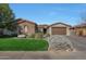 House exterior featuring stone accents, a two-car garage, and well-maintained landscaping at 19204 W Oregon Ave, Litchfield Park, AZ 85340