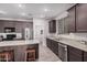 Modern kitchen with dark cabinets, granite countertops, and stainless steel appliances at 24748 W Jessica Ln, Buckeye, AZ 85326