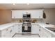 U-shaped kitchen with white cabinets and stainless steel appliances at 4713 N Brookview Ter, Litchfield Park, AZ 85340