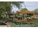 Community playground with shaded areas, play structures, and benches at 7494 E Nestling Way, Scottsdale, AZ 85255