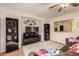 Living room with brown couch, large TV, and decorative shelving at 9010 W Hilton Ave, Tolleson, AZ 85353