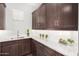 Butler's pantry with white countertops and dark brown cabinets at 9652 E Strobe Ave, Mesa, AZ 85212