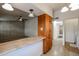 Kitchen with wood cabinets, pass-through counter, and views to hallway and living room at 10456 W Oakmont Dr, Sun City, AZ 85351