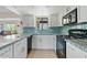 Modern kitchen with white cabinets, granite counters, and teal backsplash at 125 N Val Vista Rd, Apache Junction, AZ 85119