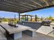 Outdoor kitchen area with grill and covered seating under pergola at 16038 W Desert Hollow Dr, Surprise, AZ 85387