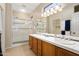 Bathroom with double sinks, shower, and walk-in closet at 16938 W Desert Rose Ln, Surprise, AZ 85387