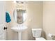 Small bathroom with pedestal sink and toilet at 16938 W Desert Rose Ln, Surprise, AZ 85387
