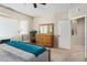 Bedroom with dresser, chair, and access to bathroom at 16938 W Desert Rose Ln, Surprise, AZ 85387