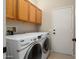 Laundry room with washer, dryer, and overhead cabinets at 16938 W Desert Rose Ln, Surprise, AZ 85387