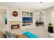 Living room with fireplace, built-in shelving, and a home office at 16938 W Desert Rose Ln, Surprise, AZ 85387