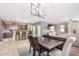 Kitchen and dining area with a farmhouse table and modern chandelier at 18348 W Hatcher Rd, Waddell, AZ 85355