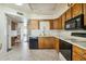 Eat-in kitchen with wood cabinets, built-in microwave, and black appliances at 2064 S Farnsworth Dr # 39, Mesa, AZ 85209