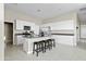 Modern kitchen with white cabinets, dark countertops, and island with seating at 40904 W Hillman Dr, Maricopa, AZ 85138