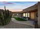 Desert landscape surrounds this Southwestern-style home with a welcoming porch and wooden door at 5581 E Superstition Blvd, Apache Junction, AZ 85119