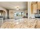 Kitchen with granite countertop island, seating, and views to living room at 5581 E Superstition Blvd, Apache Junction, AZ 85119