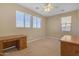 Bright bedroom with two windows, ceiling fan, and wood desks at 1087 E Nickleback St, San Tan Valley, AZ 85143