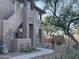 Well-maintained stucco building with a curved walkway, landscaping, and mature trees at 11500 E Cochise Dr # 1030, Scottsdale, AZ 85259