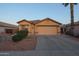 Tan house with a two-car garage and desert landscaping at 15535 N 159Th Ln, Surprise, AZ 85374