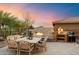 Outdoor kitchen and dining area with fireplace at 1572 W Laurel Greens Dr, Anthem, AZ 85086