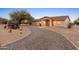 Well-maintained house with a gravel driveway and rustic wagon wheel decor at 2221 E Joy Ranch Rd, Phoenix, AZ 85086