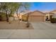 Tan house with a two-car garage and landscaped front yard at 23664 N Oasis Blvd, Florence, AZ 85132