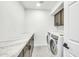 Bright laundry room with washer, dryer, and marble countertop at 5679 E Beverly Ln, Scottsdale, AZ 85254