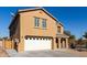 Two-story house with tan exterior, white garage door, and landscaping at 990 E Doris St, Avondale, AZ 85323