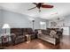 Living room featuring hardwood floors, a brown couch and a ceiling fan at 10158 E Caballero St, Mesa, AZ 85207