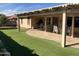 Spacious backyard with covered patio and artificial turf at 11557 E Kilarea Ave, Mesa, AZ 85209