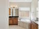 Elegant bathroom with a soaking tub, double vanity, and dark countertops at 12860 W Calle De Sol --, Peoria, AZ 85383