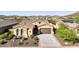 Tan two-story house with a brown door and two car garage, desert landscaping, and a mountain view in the background at 12860 W Calle De Sol --, Peoria, AZ 85383