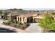 Tan house with a brown door and two car garage, desert landscaping, and mountain views in the background at 12860 W Calle De Sol --, Peoria, AZ 85383
