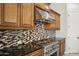 Kitchen with stainless steel range and mosaic backsplash at 12860 W Calle De Sol --, Peoria, AZ 85383