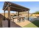 Outdoor kitchen and bar area with pergola and pool views at 12860 W Calle De Sol --, Peoria, AZ 85383