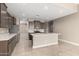 Modern kitchen with gray cabinets, large island, and stainless steel appliances at 29411 W Mitchell Ave, Buckeye, AZ 85396