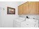 Laundry room with washer, dryer, and wood cabinets at 8500 E Southern Ave # 368, Mesa, AZ 85209