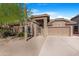 Single-story house with a tan stucco exterior, two-car garage, and desert landscaping at 8546 E Brittle Bush Rd, Gold Canyon, AZ 85118