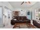 Open living area with brown leather sofas and a built-in bar at 9402 W Briarwood N Cir, Sun City, AZ 85351