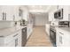 Modern kitchen featuring white cabinets, quartz countertops, and stainless steel appliances at 9507 W Spanish Moss Ln, Sun City, AZ 85373