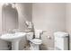 Guest bathroom with pedestal sink, toilet, and grab bars at 15971 W La Paloma Dr, Surprise, AZ 85374