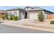 House exterior showcasing a two-car garage and neatly landscaped front yard at 16406 W Charlotte Dr, Surprise, AZ 85387