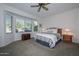 Bright bedroom with a queen bed, window seating, and wood nightstands at 20888 N Canyon Whisper Dr, Surprise, AZ 85387