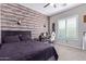 Bedroom with wood-like wall accents, a bed, and a workspace at 21121 E Marsh Rd, Queen Creek, AZ 85142