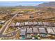 Aerial view showcasing a community with desert landscape, modern homes, and pools at 21354 W Minnezona Ave, Buckeye, AZ 85396