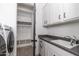 Laundry room with sink, cabinets, and storage at 21354 W Minnezona Ave, Buckeye, AZ 85396
