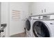 Laundry room with washer, dryer, and built-in shelving at 21354 W Minnezona Ave, Buckeye, AZ 85396