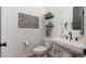 Powder room with white sink, toilet and decorative wall art at 21354 W Minnezona Ave, Buckeye, AZ 85396